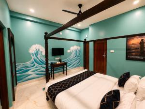 a bedroom with a bed with a painting of the ocean at Arka by Utkalio in Puri