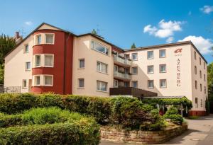 an apartment building with bushes in front of it at Hotel Azenberg in Stuttgart