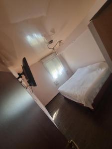 a small bedroom with a bed and a window at BlueStay in Qiryat Yam