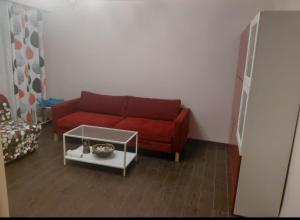 a living room with a red couch and a table at BlueStay in Qiryat Yam +1 photo