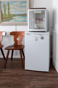 a microwave on top of a refrigerator next to a chair at Private Rooms near Glarus, Shared Bath in Näfels