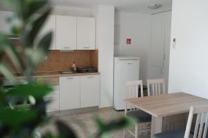a kitchen with white cabinets and a wooden table at GARDEN in Nerezine