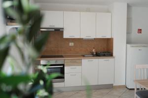 a kitchen with white cabinets and a sink at GARDEN in Nerezine