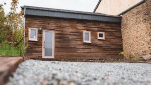 a wooden building with a door on the side of it at Atelier 69 Loveroom in Paliseul