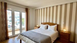 a bedroom with a bed and a sliding glass door at Alice - Private Pool - 10 Guests - Albufeira in Albufeira