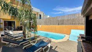 a swimming pool with lounge chairs next to a building at Alice - Private Pool - 10 Guests - Albufeira in Albufeira