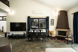 a living room with a table and chairs and a television at Petra Kazarma in Kymi