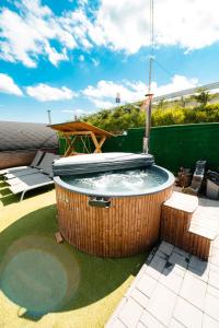 a hot tub on a patio with a table at Cabana Brad Apuseni Villa in Cotorăşti