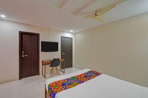 a bedroom with a bed and a desk and a tv at Via Silver Suites in Hyderabad
