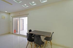 a table and chairs in a room with a window at Via Silver Suites in Hyderabad