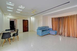 a living room with a blue chair and a table at Via Silver Suites in Hyderabad