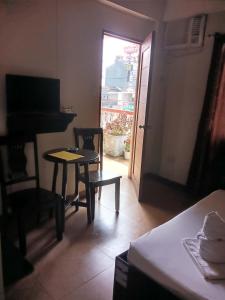 a room with a table and a chair and a door at Central View Apartelle in Angeles