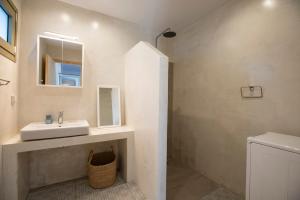 a white bathroom with a sink and a mirror at Topos Patela in Kalithies +13 photos