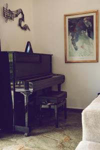 a piano in a living room with a picture on the wall at Petra Kazarma in Kymi