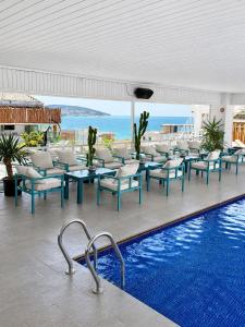 a swimming pool with tables and chairs and the ocean at Mandarin Hotel & Spa Tanger in Tangier