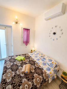 a bedroom with a bed with a comforter and a clock at Stella Marys Sud in Olbia