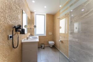 a bathroom with a shower and a sink and a toilet at 3B Suites Boutique Hotel in Sarandë +49 photos
