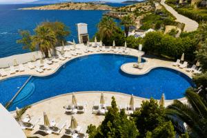 an image of a swimming pool with chairs and umbrellas at Başka Resort Bodrum in Bodrum City