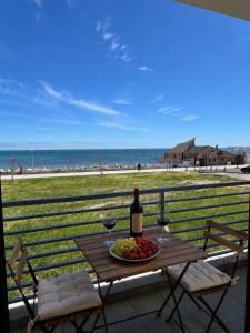 a table with a bottle of wine and a plate of fruit at Pensiunea EDY in Mangalia