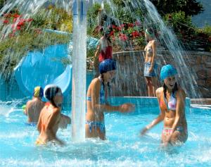 a group of children playing in a swimming pool at Appartamenti Residenza Pineta in Molveno