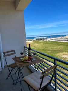 a table with wine glasses and a bowl of fruit on a balcony at Pensiunea EDY in Mangalia +9 photos