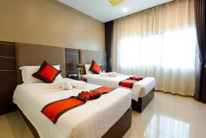 a bedroom with two beds and a window at Ease Jomtien by Clubhouse in Jomtien Beach