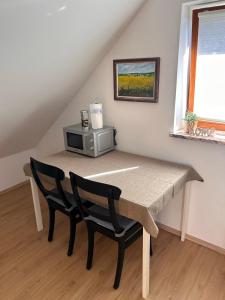 a dining room table with two chairs and a microwave at Green View Apartment in Wülfrath