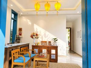 a dining room with a table and chairs and yellow lights at Metta Living Hoi An in Thanh Ðông (1)