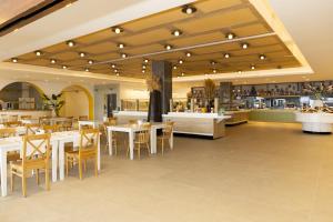 a restaurant with white tables and chairs and a cafeteria at Başka Resort Bodrum in Bodrum City