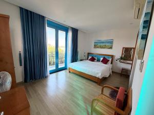 a bedroom with a bed and a large window at Metta Living Hoi An in Thanh Ðông (1) +28 photos