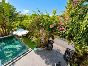 an aerial view of a backyard with a swimming pool and flowers at Metta Living Hoi An in Thanh Ðông (1)