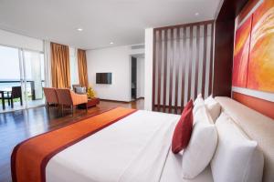 a bedroom with a large bed and a living room at Citrus Waskaduwa in Kalutara