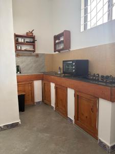 a kitchen with wooden cabinets and a microwave at La luna di zanzibar in Kiwengwa