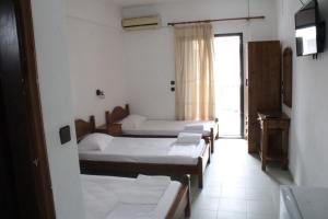 a room with four beds and a window at Solis Apartments in Kallithea Halkidikis