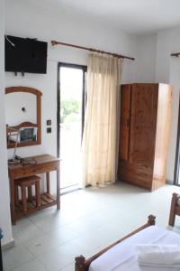 a bedroom with a bed and a desk and a window at Solis Apartments in Kallithea Halkidikis
