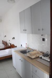 a kitchen with white cabinets and a sink at Solis Apartments in Kallithea Halkidikis