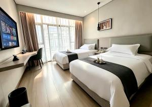 a hotel room with two beds and a flat screen tv at Yiwu Bai Heng Hotel in Yiwu +55 photos