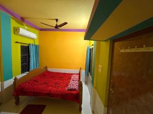a bedroom with a red bed in a colorful room at Sundarban Residential Hotel in Pātharpratima Island