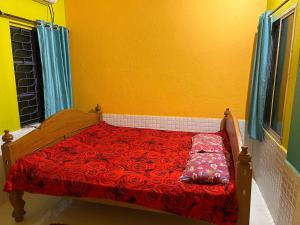 a bedroom with a red bed with a yellow wall at Sundarban Residential Hotel in Pātharpratima Island