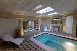 a swimming pool in a room with a tile floor at Palazzo Di Acqua in Le Mans