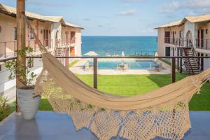 a hammock on a balcony overlooking the ocean at Coleção Falésias de Pipa- by Arcbio Experience in Pipa