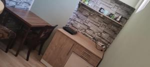a kitchen with a counter with a brick wall at DIAstan in Zrenjanin +13 photos