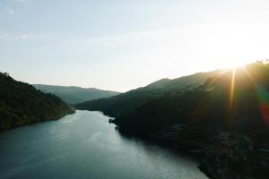 a view of a river with the sun shining on it at Douro Royal Valley Hotel & Spa in Riba Douro