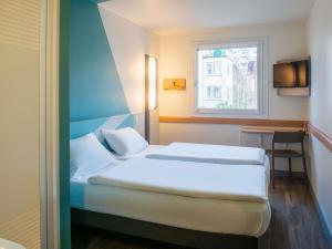a hotel room with two beds and a window at ibis budget Ulm City in Ulm +76 photos