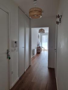 an empty room with a hallway with wooden floors and a room with a table at T2 Suresnes Proche La Défense Paris Parking Fibre in Suresnes