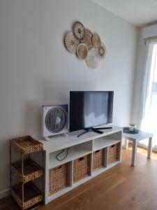 a living room with a tv and a fan at T2 Suresnes Proche La Défense Paris Parking Fibre in Suresnes