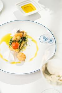 a white plate with food on a table at Douro Royal Valley Hotel & Spa in Riba Douro +51 photos