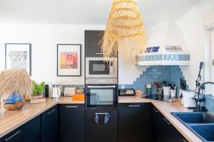 a kitchen with black cabinets and a counter top at Maison Cosy Bohème Chic Biarritz in Biarritz