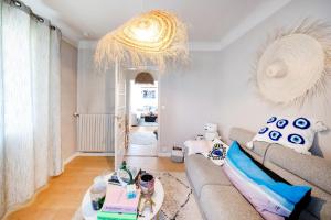 a living room with a couch and a chandelier at Maison Cosy Bohème Chic Biarritz in Biarritz