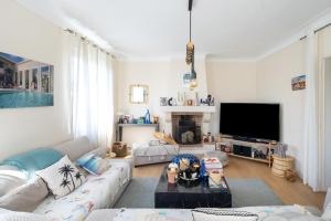 a living room with a couch and a tv at Maison Cosy Bohème Chic Biarritz in Biarritz